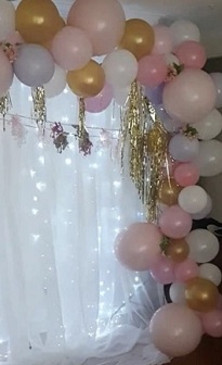 Balloons decor with shades of pink and gold balloons with gold tassels and lights (Curtain not included) and leaves