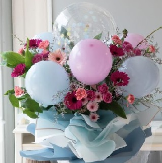 5 Air filled pink blue balloons on sticks and 12 gerberas with leaves in a bouquet
