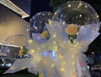 Transparent 3 Bobo Balloon with 3 Yellow rose inside and wrapped in white and pale yellow wrapping and led fairy light string