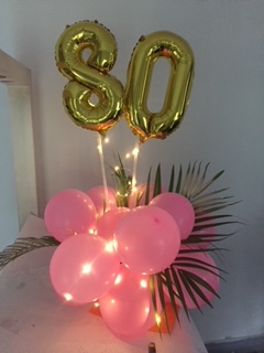 double digit balloon for birthday or anniversary with pink 20 balloons at bottom and lights and leaves