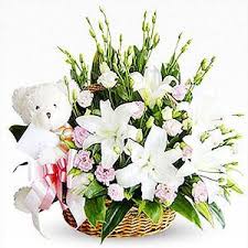 A basket of lilies with teddy bear